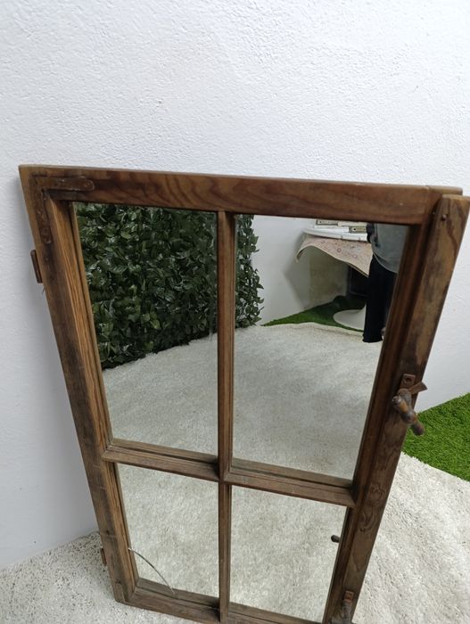 Lustro w starej drewnianej ramie okiennej.