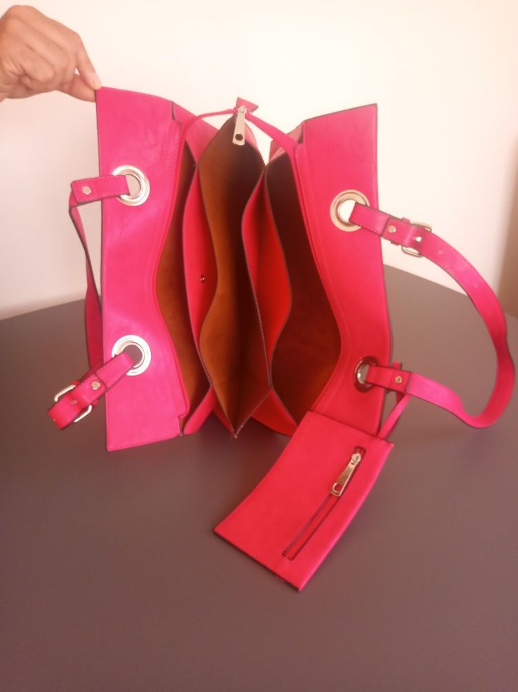 Carteira cor de rosa fúcsia com alça extensível.