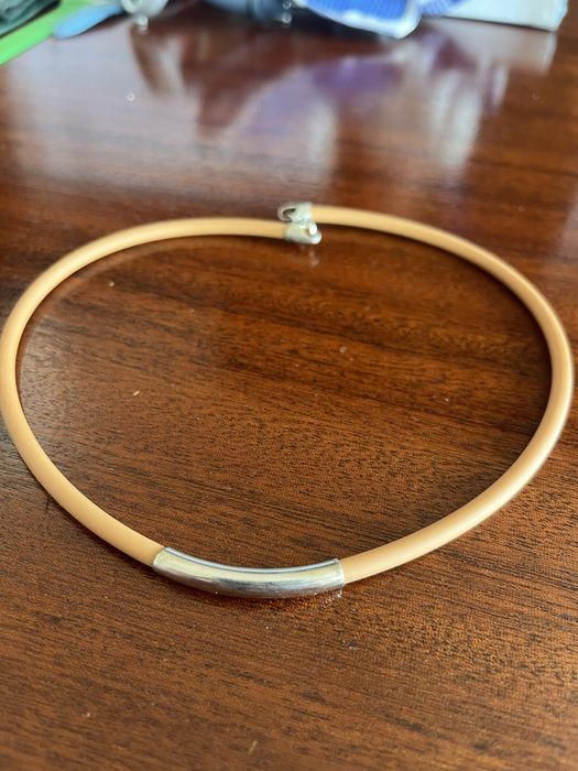 Colar de plastico com peca de metal com caixa