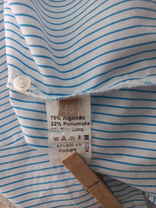 Camiseiro branco com riscas azuis.