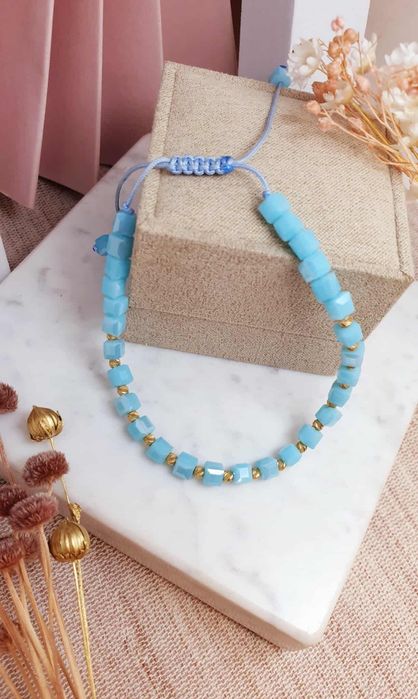 Bransoletka na sznureczku z niebieskimi koralikami.i I złotymi kulkami