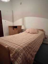 Mobília de quarto individual com cama, roupeiro e cómoda.