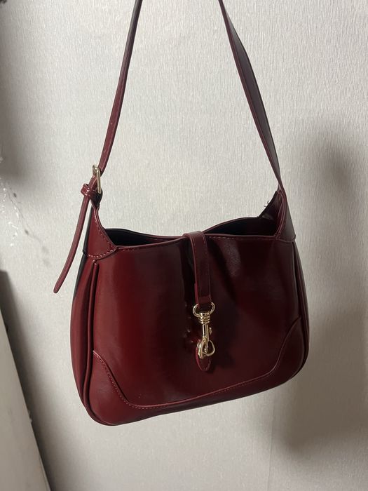 Сумка бордового кольору.