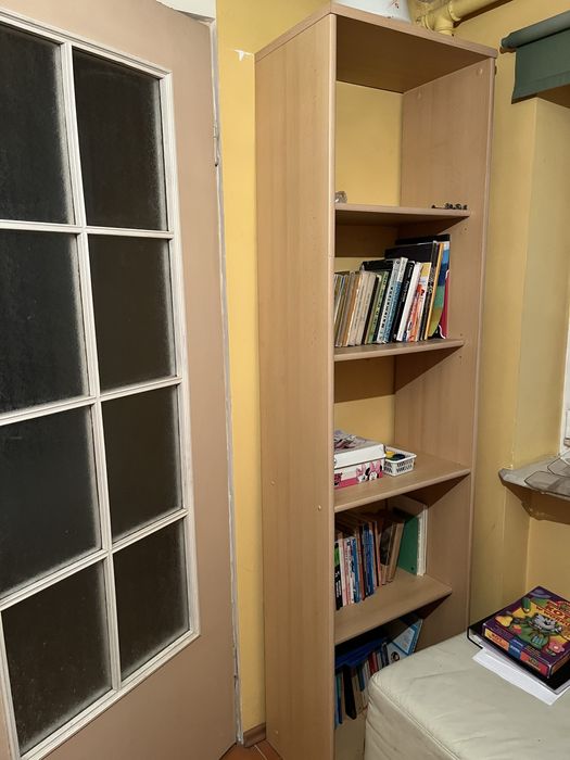 Wysoka, jasna szafka, regał, biblioteczka