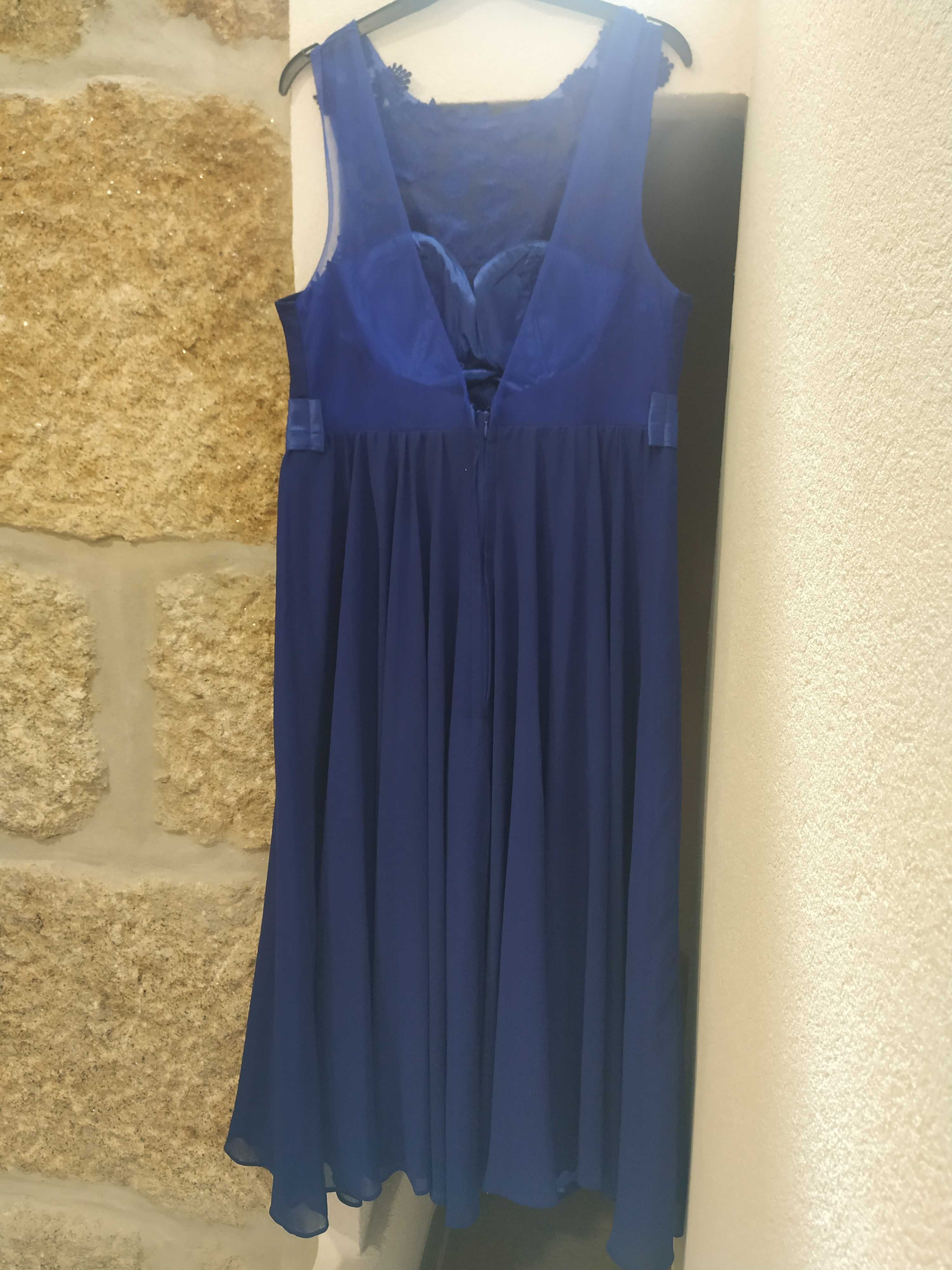 Vestido comprido azul de cerimônia e mala de mão