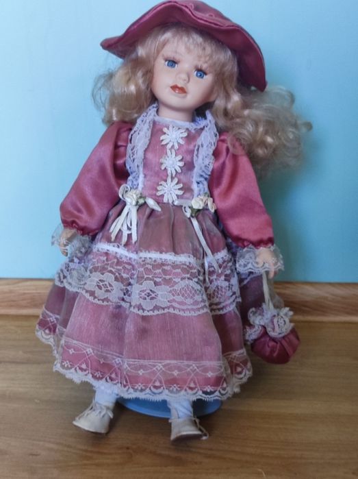 Duża porcelanowa lalka retro na stojaku.