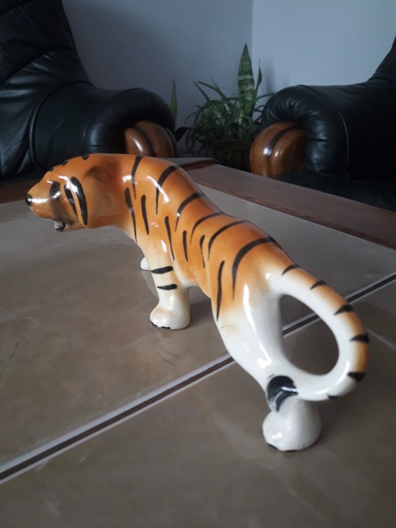 Porcelanowa figurka przyczajonego tygrysa.