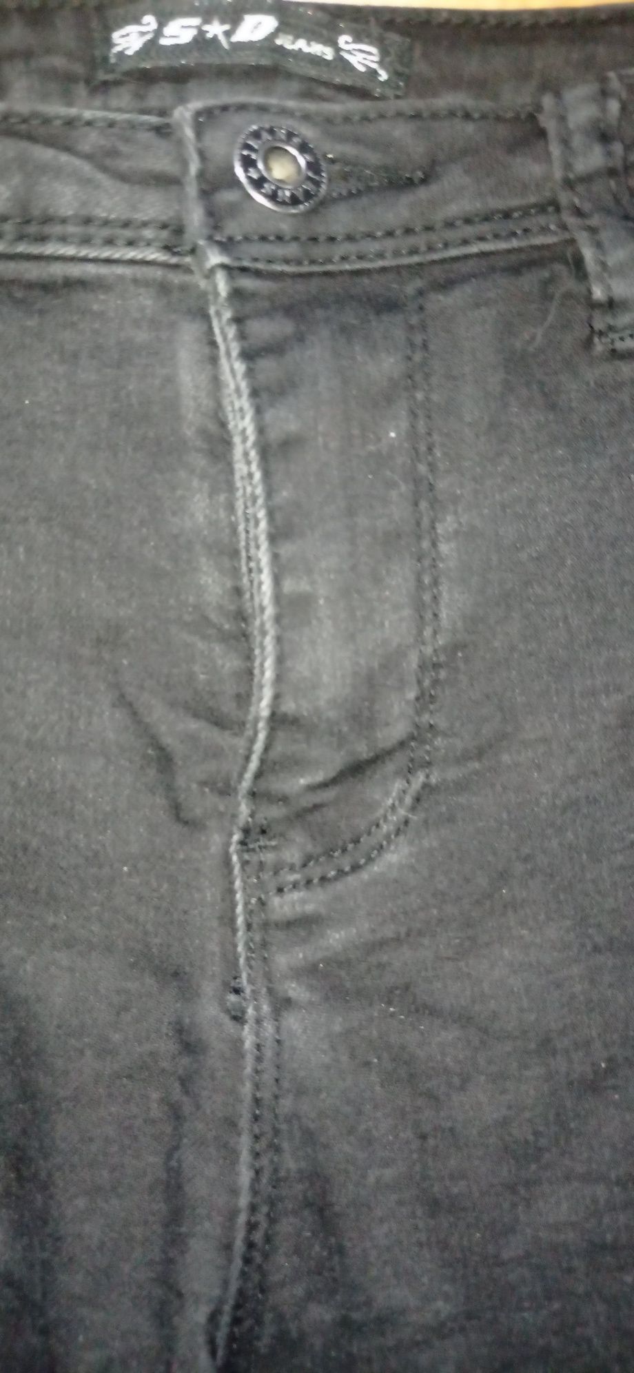 Czarne spodnie jeansowe z wadą
