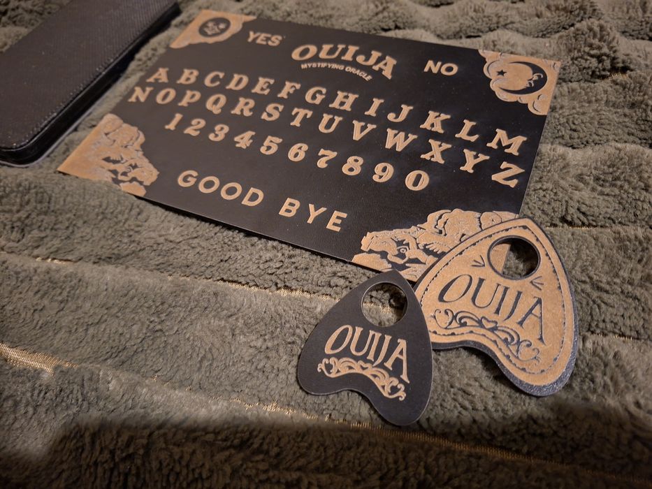 Mała tabliczka ouija z dwoma kostkami.