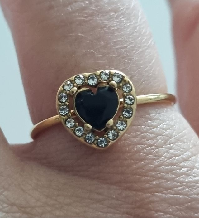 Anel dourado, em aço, com coração preto rodeado de zirconias.Ajustável