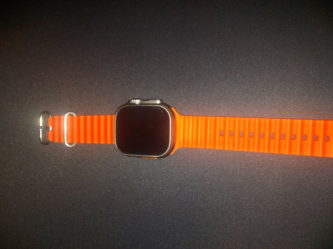 smartwatch z pomarańczowym paskiem jakiś applewatch