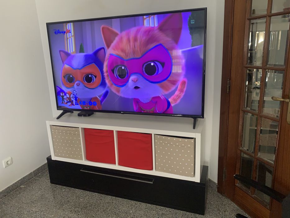 Tv 65 com movel branco e preto e gavetas