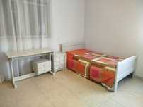 Cama individual, mesa de cabeceira e escrevaninha