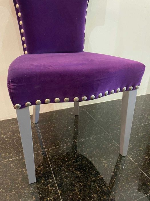 Cadeira moderna em veludo roxo com tachas metálicas de exposição