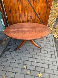 Stary stół wykonany z drewna, posiadający kółka.