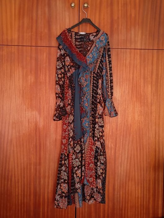 Vestido longo de tons escuros.