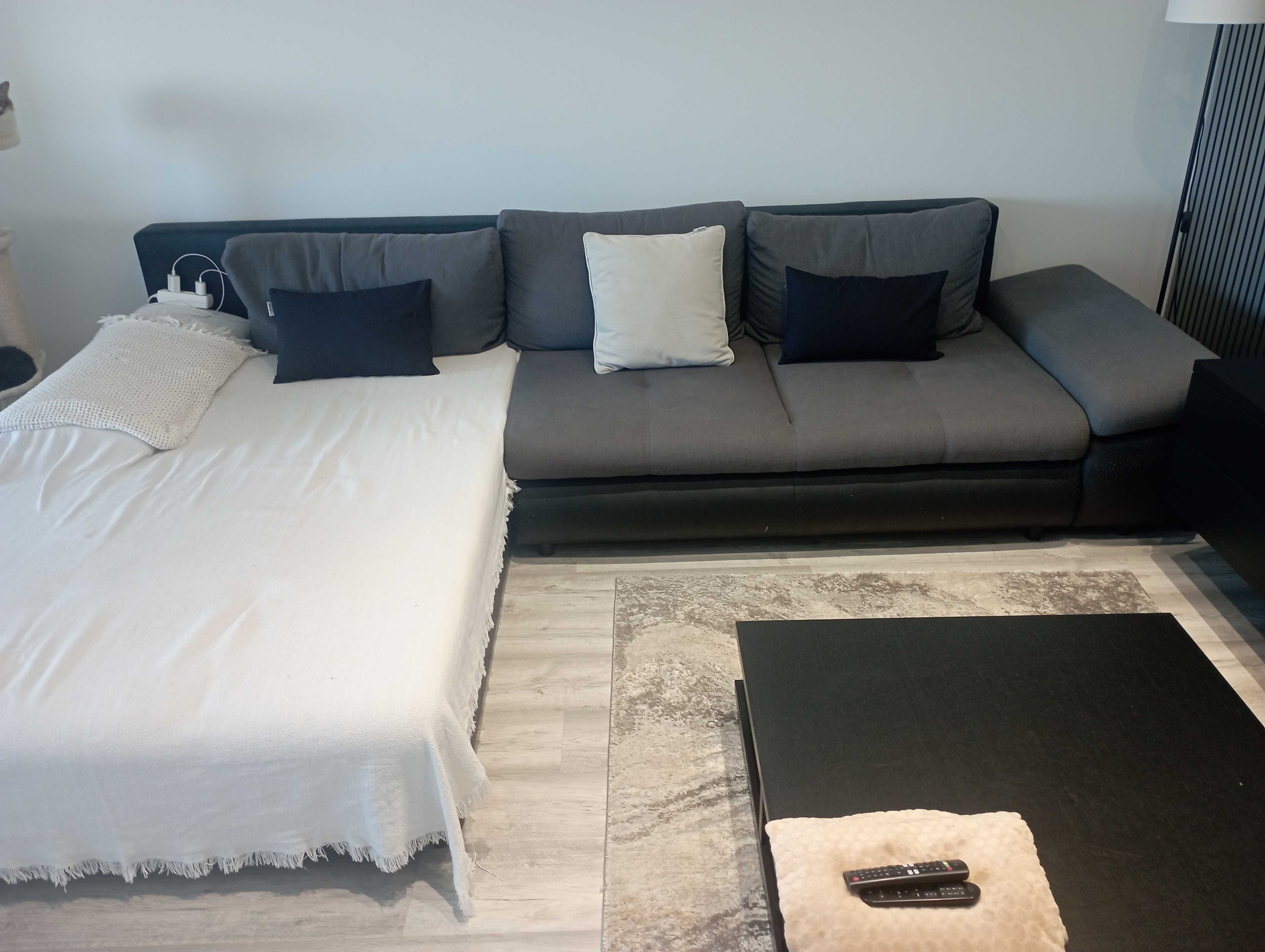Sofá com 3 metros de comprimento e uma grande cama.