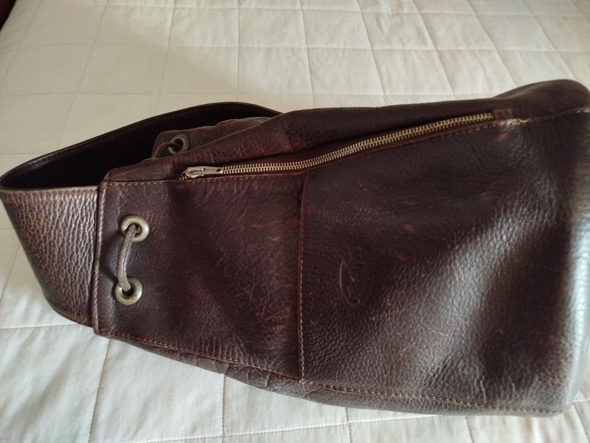 Mochila em pele castanha e bolsa preta . Ambas em pele