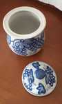 Pote branco e azul, com tampa, com desenhos de uvas.