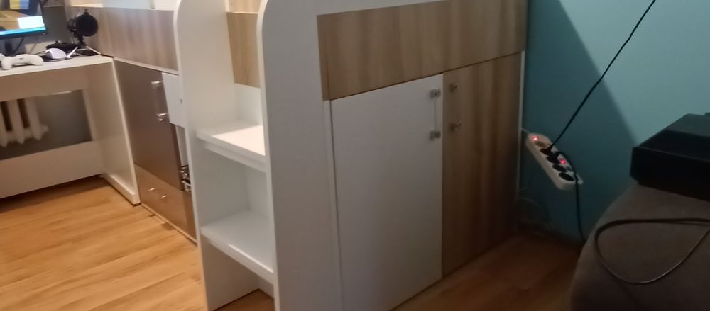 Łóżko dziecięce z szafką, szufladami, półkami i biurkiem.