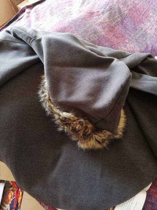 Capa com capuz e fita com pompons para apertar