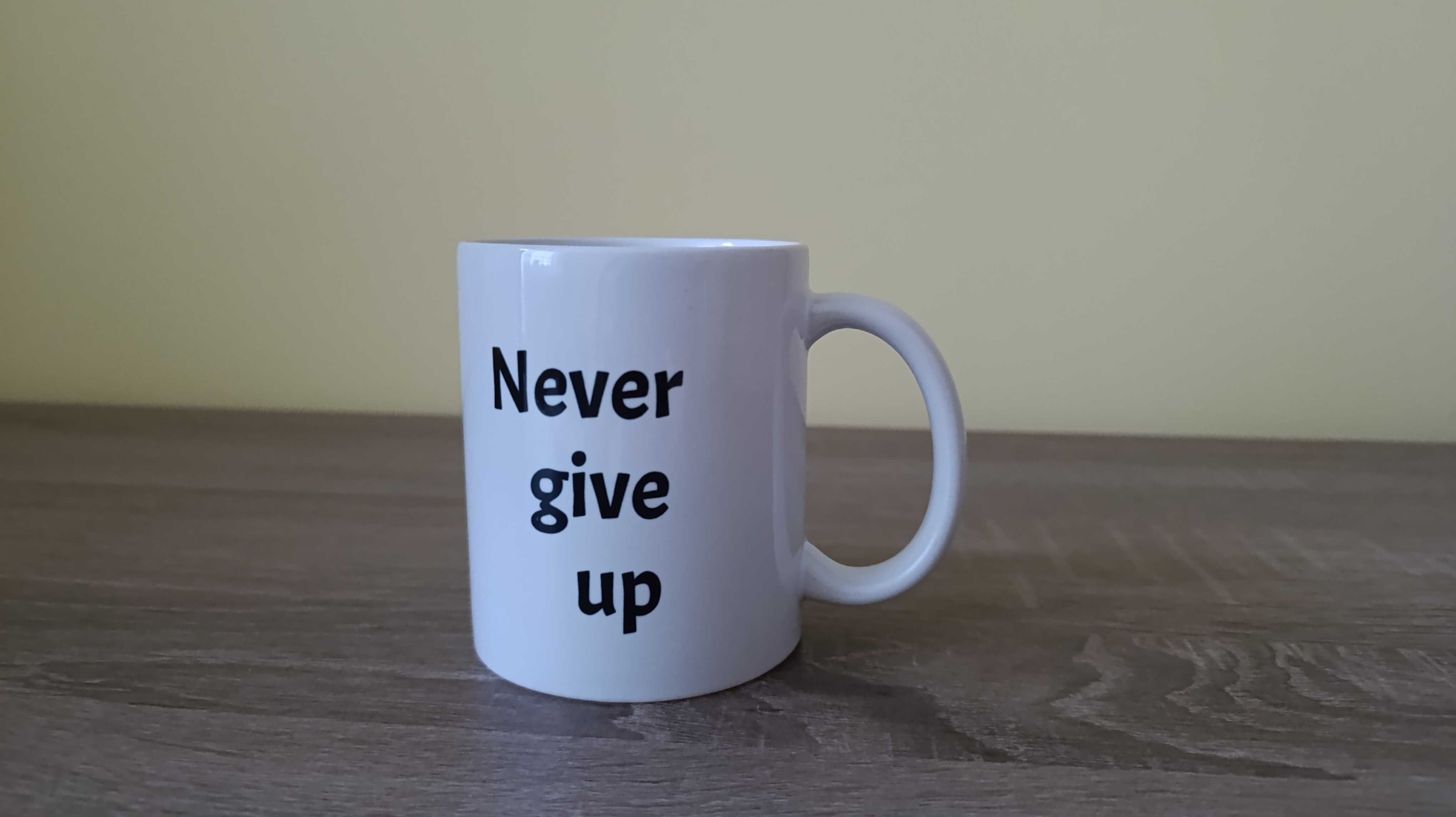 Nowy biały kubek 330 ml z napisem "Never give up"