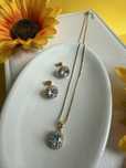 Conjunto flor cravejado com pedras de zirconia folheado a ouro.