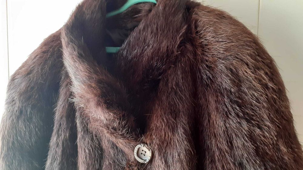 Casaco em pele de Lontra, em estado novo, com 2 bolsos e um botão.