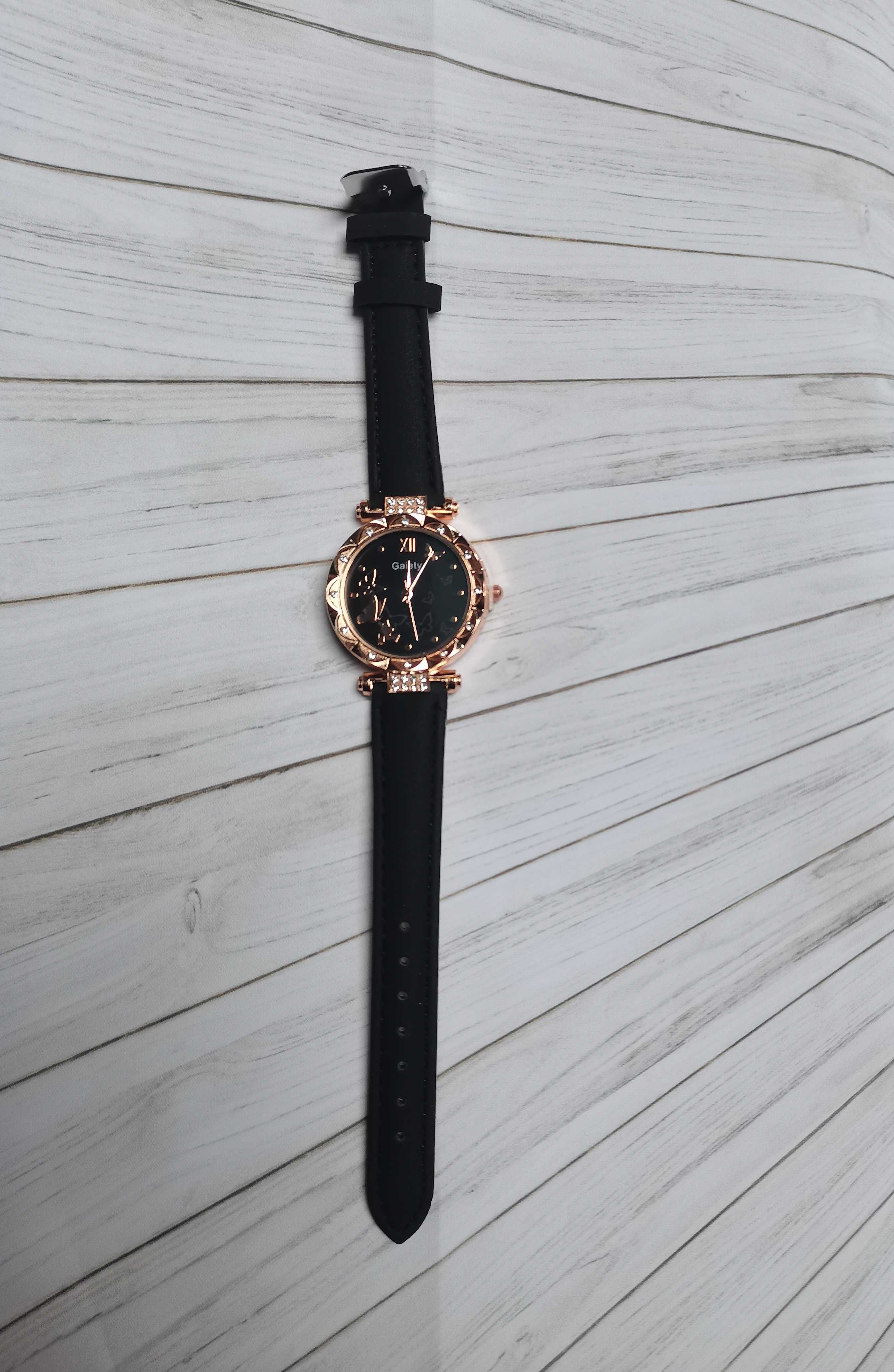 Elegancki zegarek analogowy ze zdobieniami i motylkami
