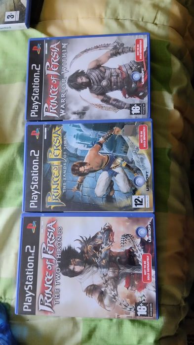 PlayStation 2 com dois jogos clássicos e dois comandos