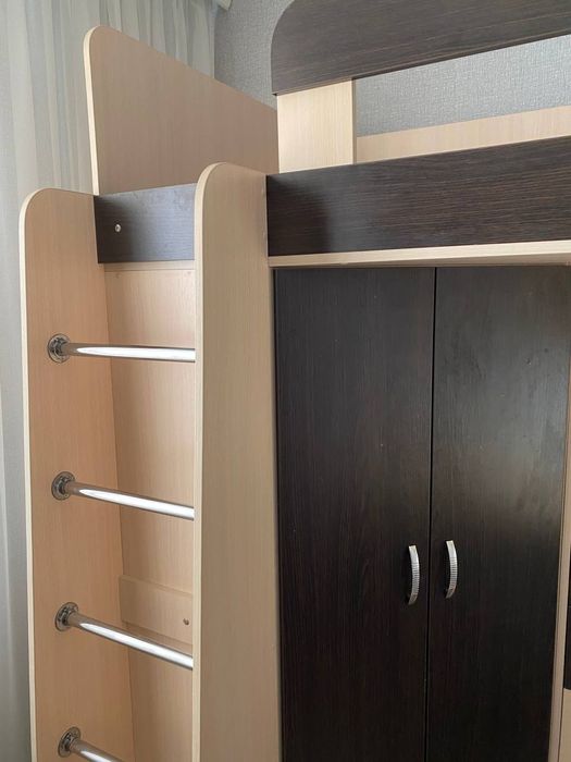 Ліжко двоповерхове разом із столом, поличками та шафою.