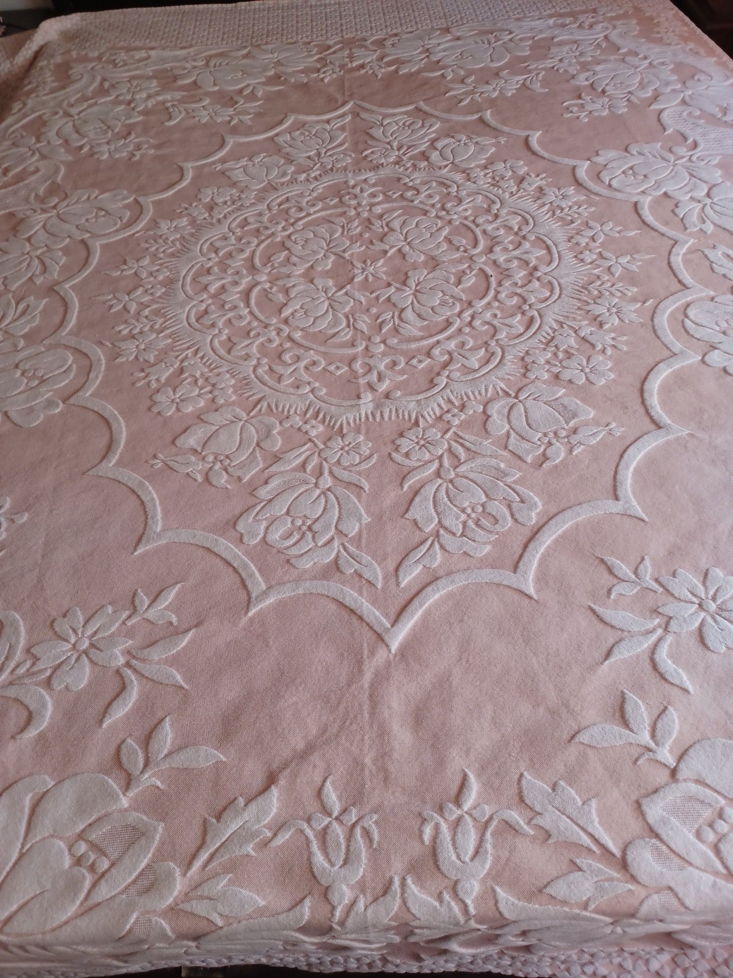 Colcha de de casal cor de rosa com desenhos florais.
