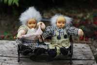 Dwie lalki siedzące na ławce Babcia i Dziadek