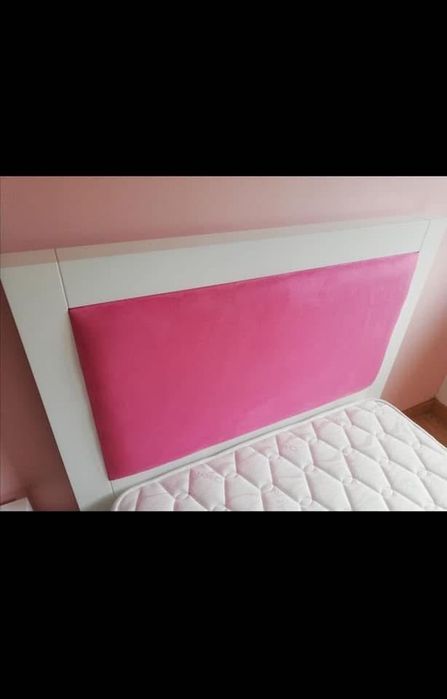 Cama de solteira com mesinha de cabeceira com duas gavetas.