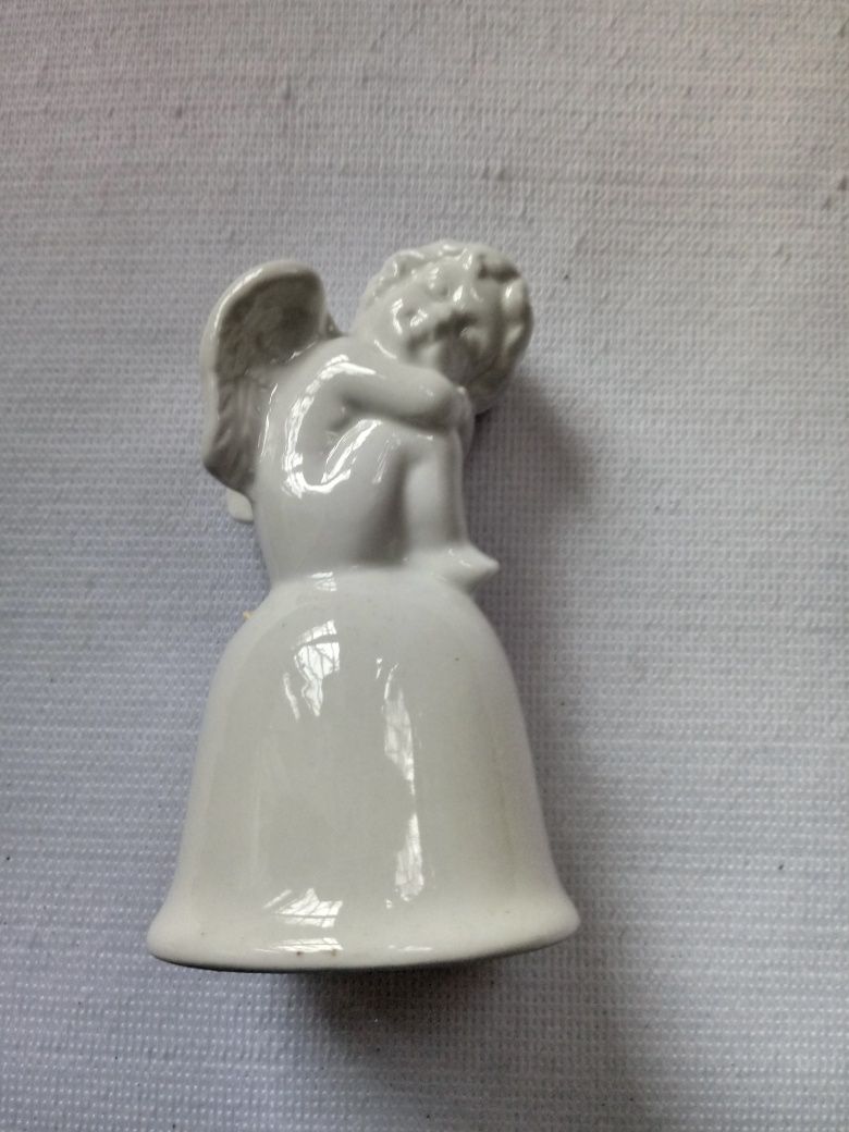 Nowy aniołek porcelany , siedzący na dzwoneczku.