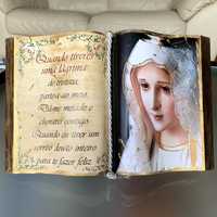 Livro aberto decorativo com Nossa Senhora e pequeno texto.