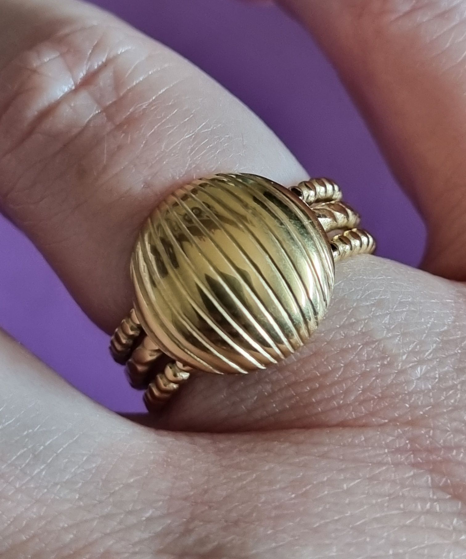 Anel dourado, em aço, com meia bola riscada. Ajustável