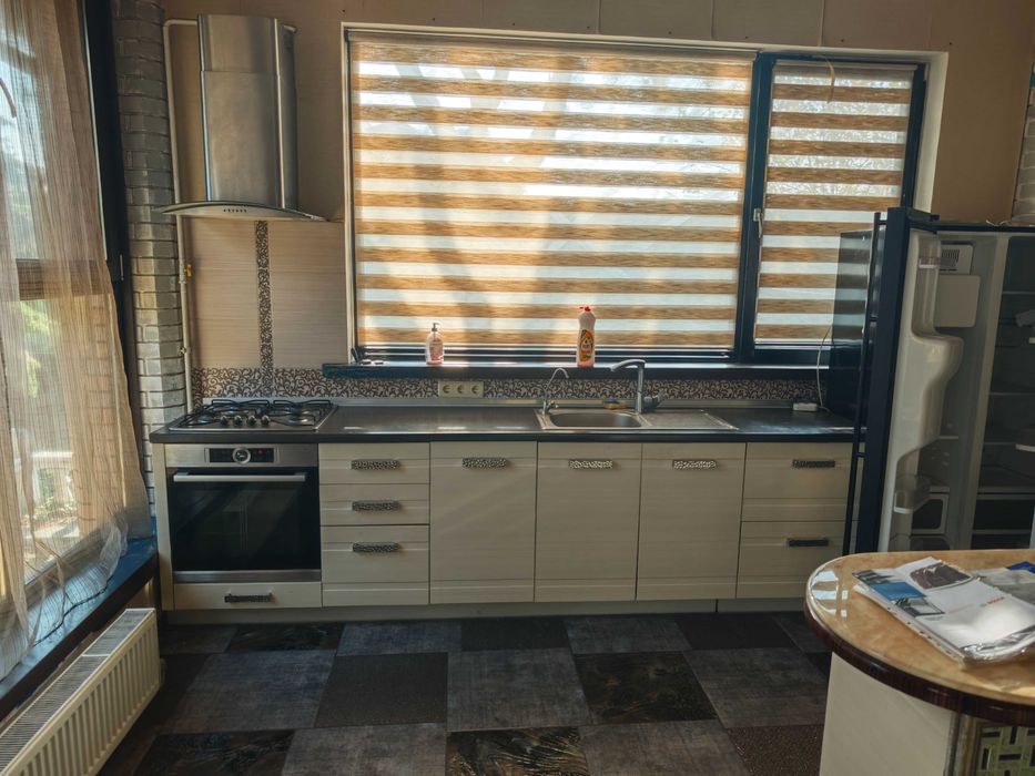 Кухня з газовою пічкою посудомийка та витяжка раковина