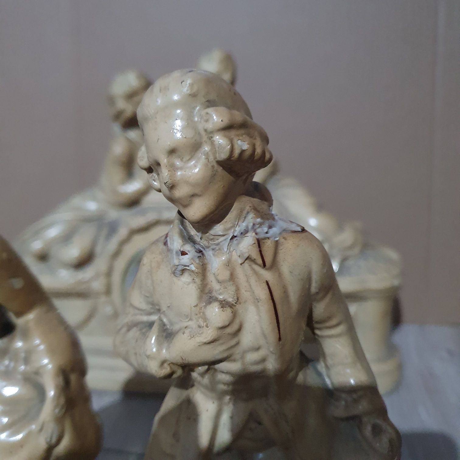 Stary ceramiczny zegar z dwoma figurkami.