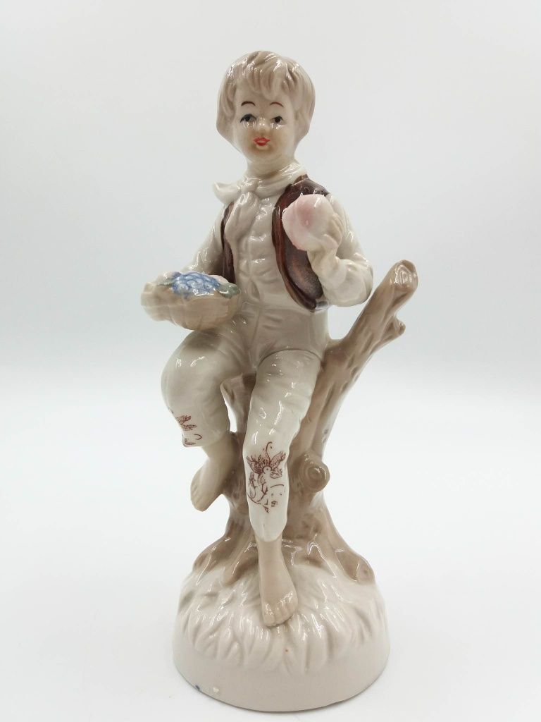 Śliczna porcelanowa figurka chłopca na drzewie