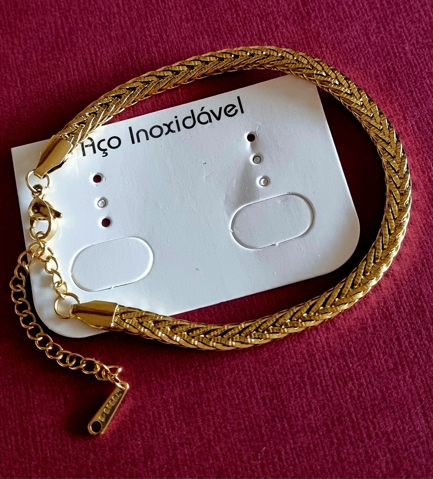 Pulseira dourada, em aço inoxidável. Tem extensor