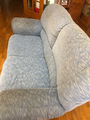 1 sofá azul, bastante usado