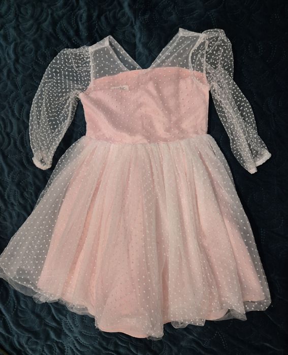 Piękna sukienka bladoróżowa z przezroczystymi rękawami i kokardą