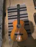 Guitarra clássica usada, palheta e conjunto de cordas