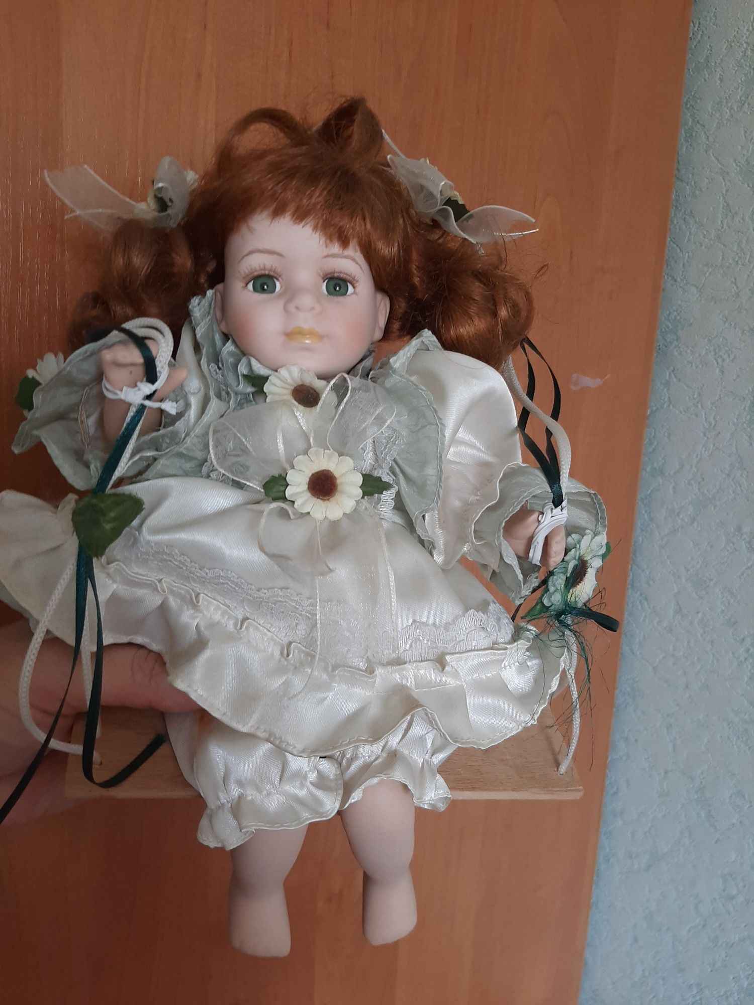 Фарфоровая кукла на качелях
