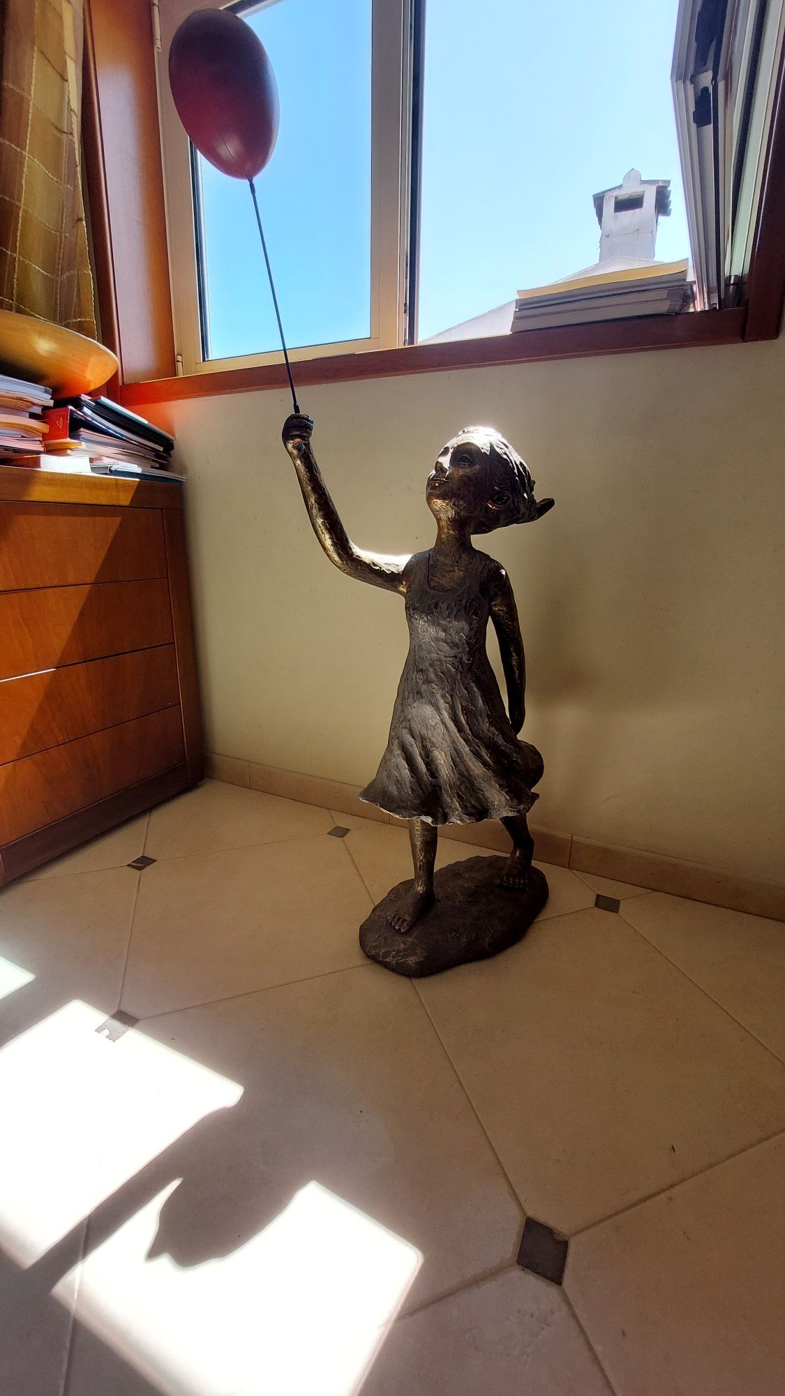 Escultura de menina com balão