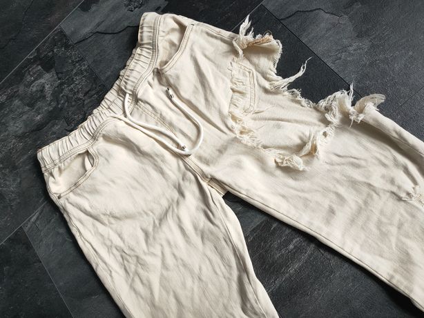Spodnie z jeans joggery z dziurą na udzie kremowe M