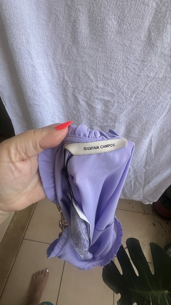 Blusa com alças de metal douradas.