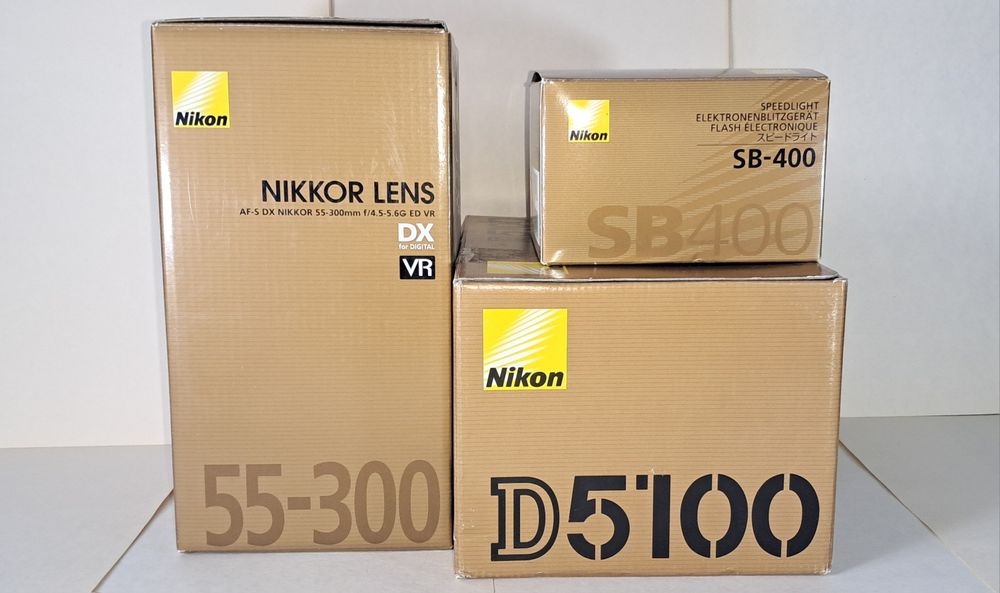Nikon D5100, разом з об'єктивом NIKKOR 55- 300 мм і фотоспалахом