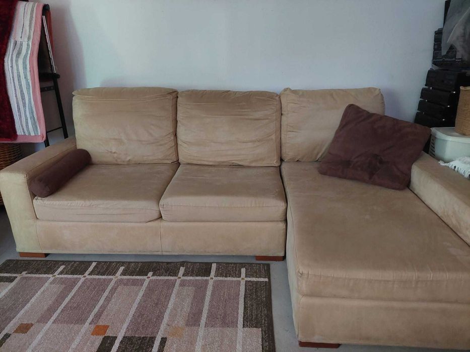 Sofá côr bege com chaise long  à esquerda .
